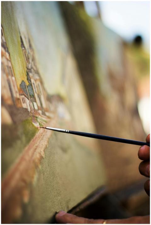 An artist's hand skillfully paints on a canvas out
