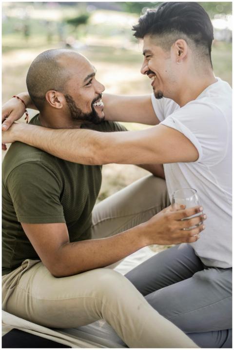 A joyful interracial gay couple embracing and smil