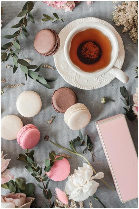 A delicate arrangement of tea with macarons and fl