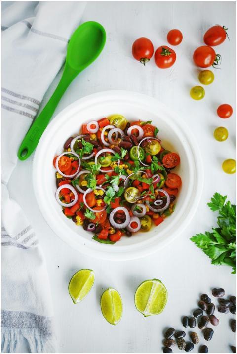 A vibrant salad with tomatoes, onions, and herbs,