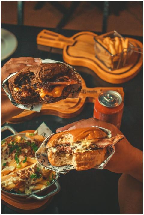 Close-up of two cheeseburgers with fries and a dri