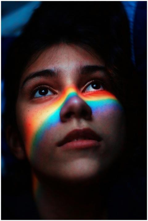 Portrait of a woman with a rainbow light across he