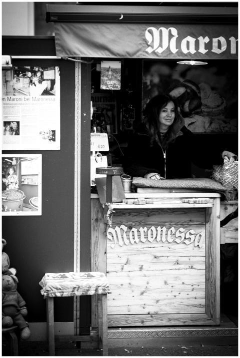 Monochrome image of a vendor standing at a shopfro