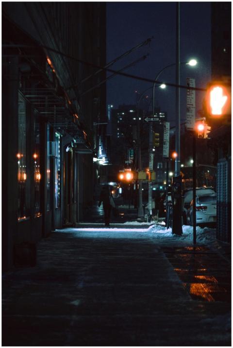 A serene snowy urban street at night illuminated b