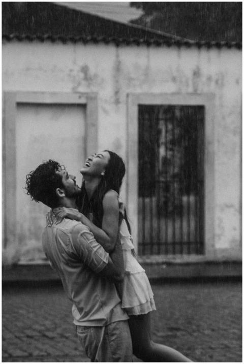 Joyful couple hugging in the rain, capturing a mom