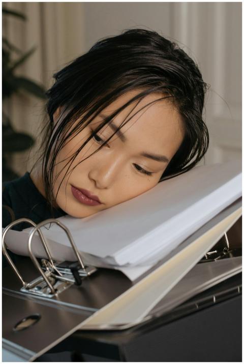 Young woman exhausted at work, resting head on sta