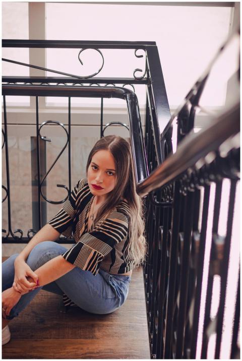 Young woman with long hair sitting on a staircase,