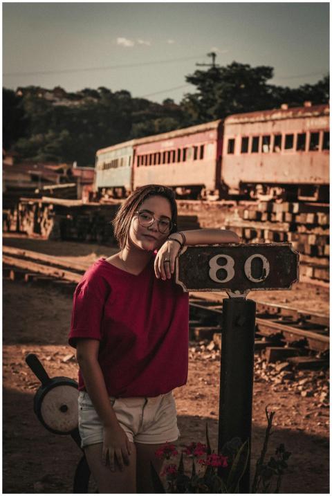 Woman posing by a vintage train station in Brazil,
