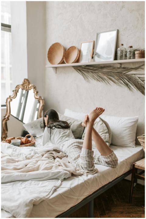 A woman lies comfortably on a bed in a stylish bed