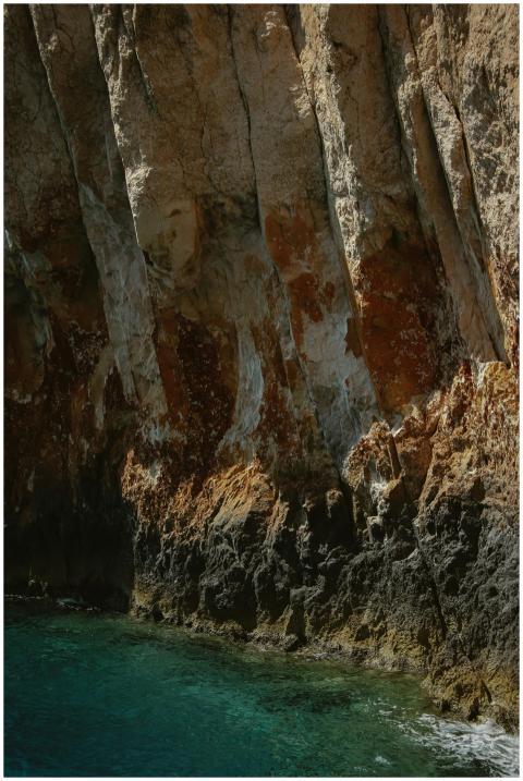 Majestic rocky cliffs rising above the clear sea i