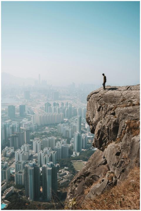 Man stands on cliff overlooking stunning Hong Kong