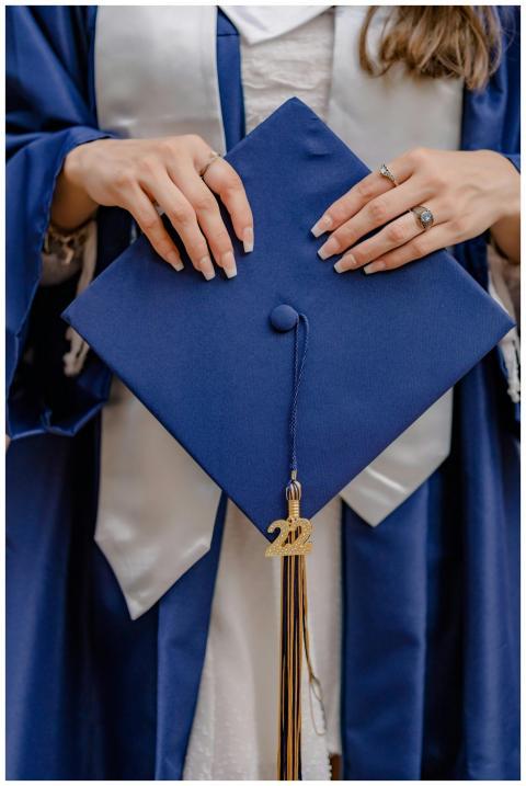 A close-up shot of a graduate holding a navy gradu