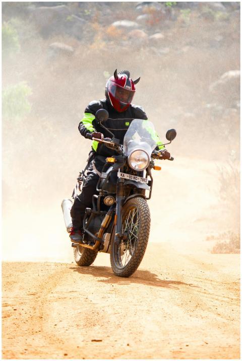 A motocross rider navigates a dirt trail with skil