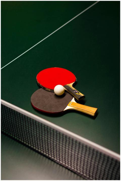 Table tennis paddles and ball on a green table. Id