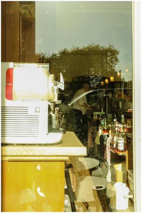 View through a window into a bustling cafe in Pari