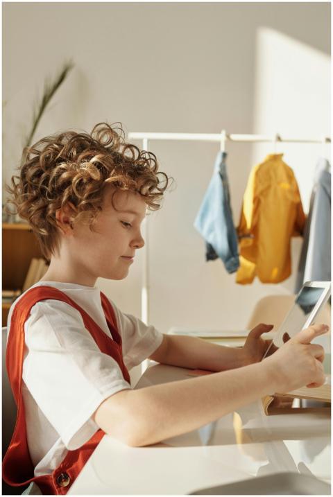 Young boy focused on using a tablet for learning i