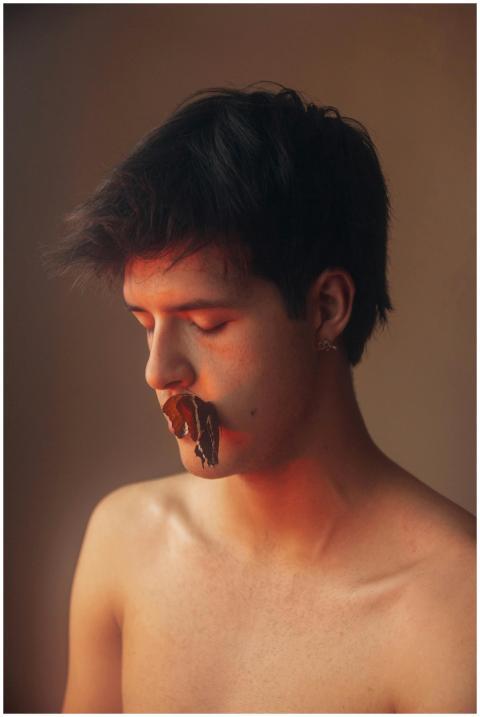 Young man with a black butterfly on lips in soft a