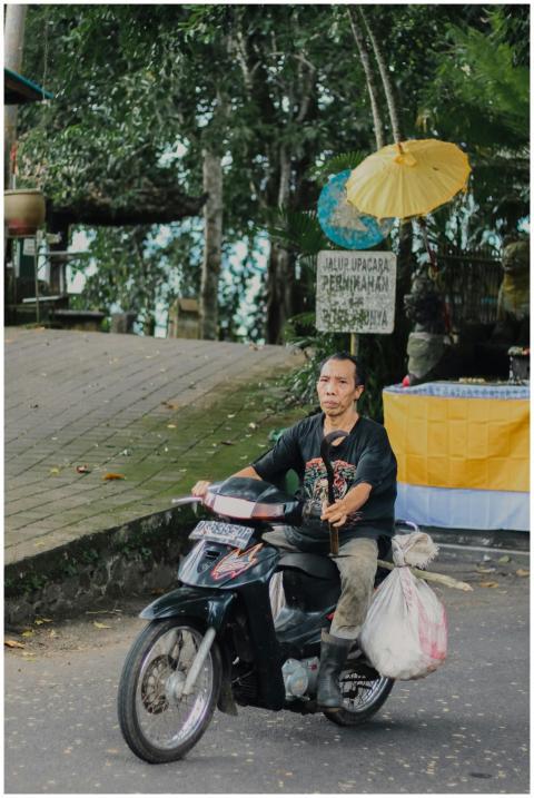 Asian man riding a motor scooter on a street in Ba