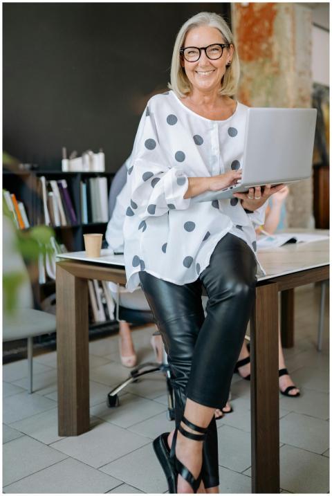 Senior woman wearing glasses, smiling while holdin