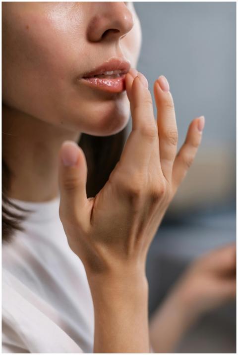 Close-up of a woman's hand applying lip balm, high