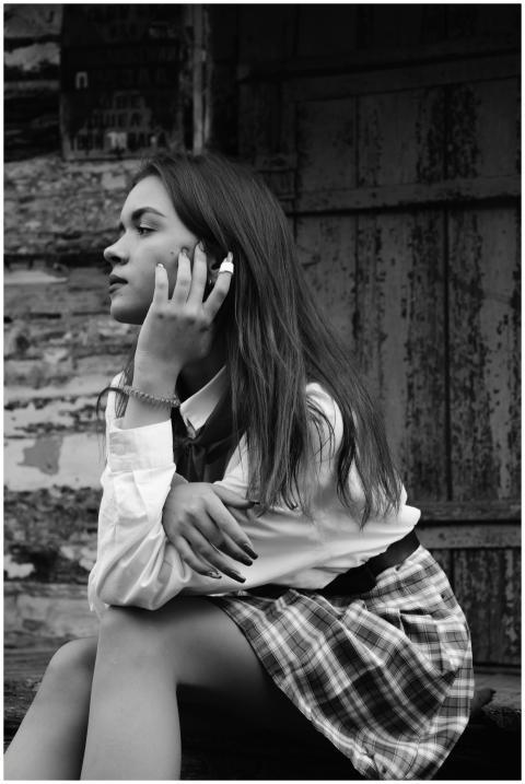 Monochrome portrait of a teenage girl sitting with