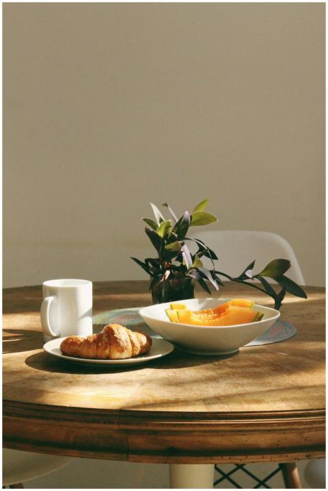 Cozy morning setup with a croissant, coffee, and f