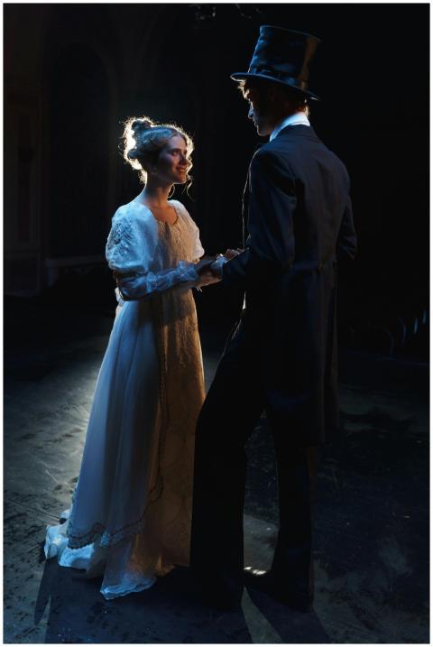 A man and woman in Victorian costumes enjoying a r