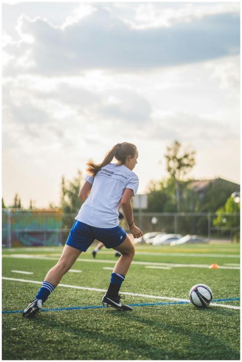 Young female soccer player practicing on a field d