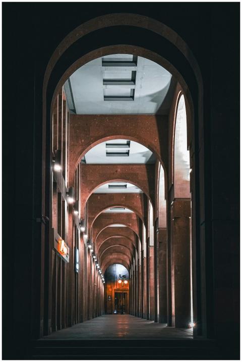 A mesmerizing view of an arched corridor at night