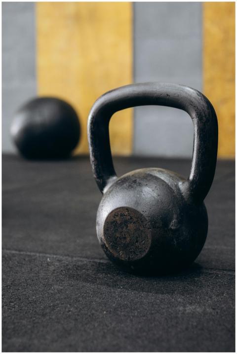Rusty kettlebell on gym floor with blurred backgro