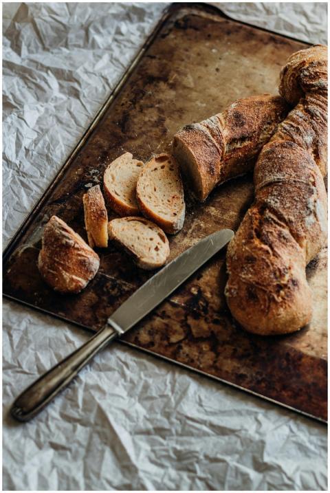 Freshly baked rustic bread loaf with slices on a t