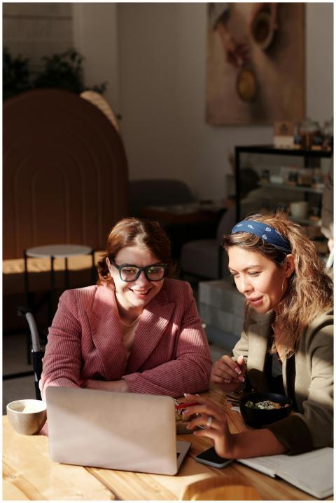 Two women collaborating on a project in a cozy caf