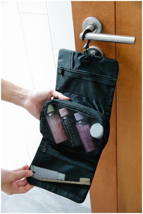 A black toiletry bag with toiletries hanging on a