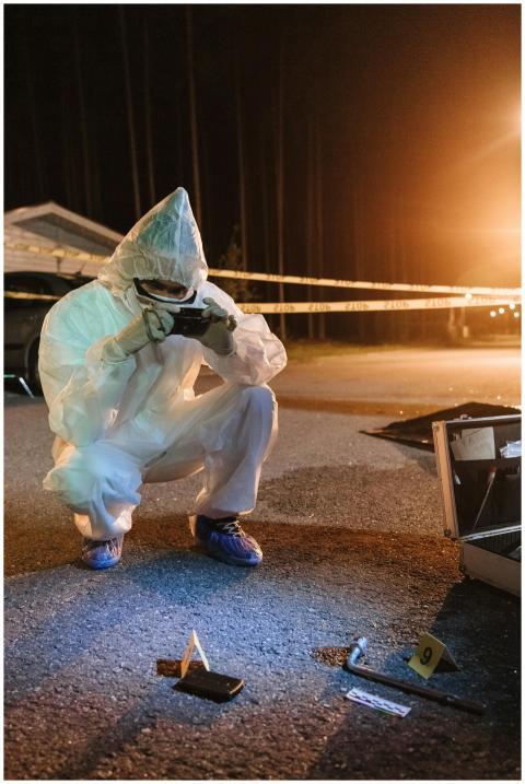 Investigator in protective gear photographing evid