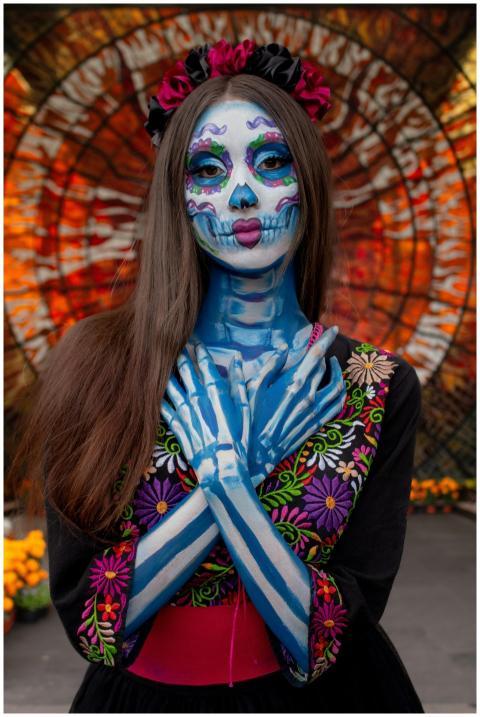 Woman with vibrant Day of the Dead face paint and