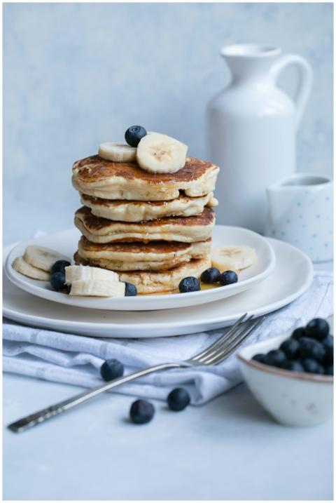 Yummy pancakes topped with bananas and blueberries