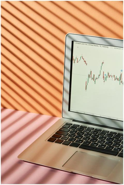 Laptop displaying stock market graphs with creativ