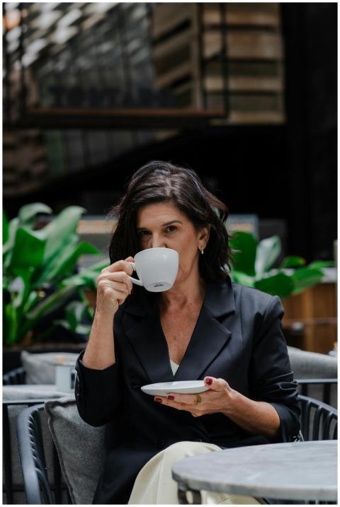 Stylish woman sipping coffee in a modern indoor ca