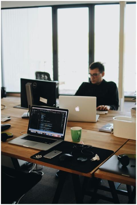A web developer working on code in a modern office