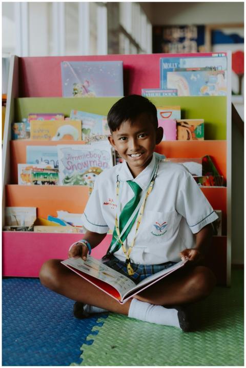 Young schoolboy in uniform reading a book in a vib