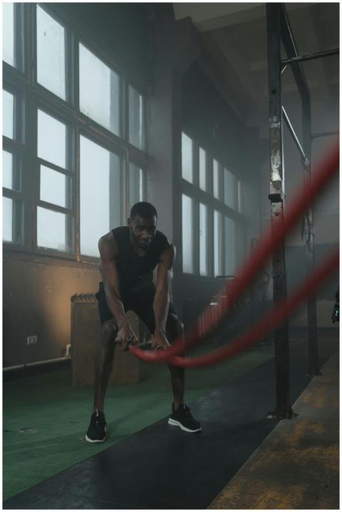 Black man performing crossfit training with battle