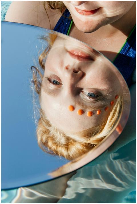 Artistic reflection of a woman with orange facial