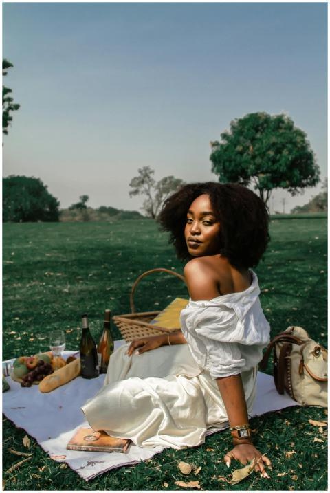 A woman enjoys a serene picnic on a sunny day with