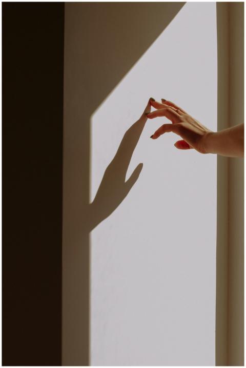 A human hand reaches out, casting a shadow on a su