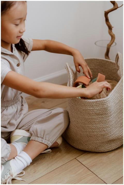 Young girl organizing toy blocks in a woven basket