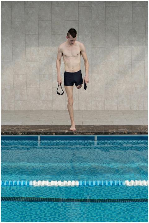 Young amputee athlete preparing to swim at an indo