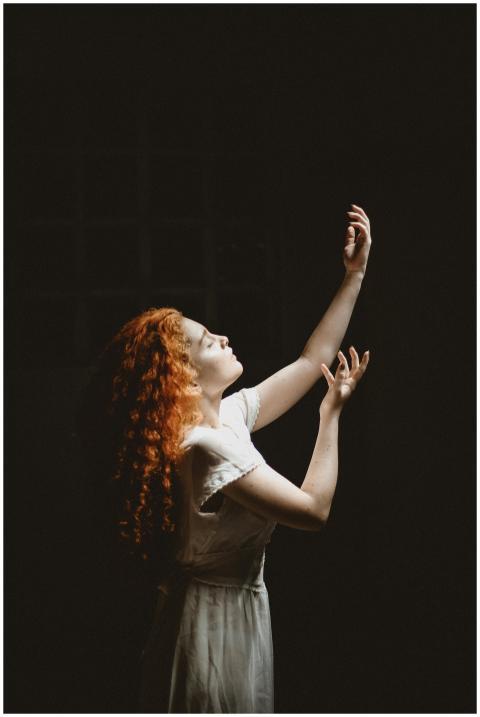 Elegant woman with red hair posing gracefully agai