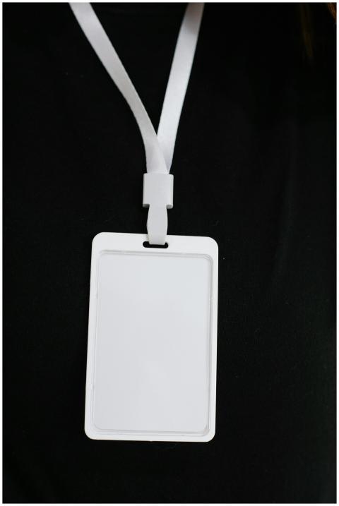 Plastic name tag with white ribbon and blank paper