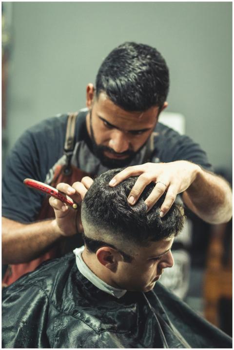 A professional barber expertly cutting a man's hai