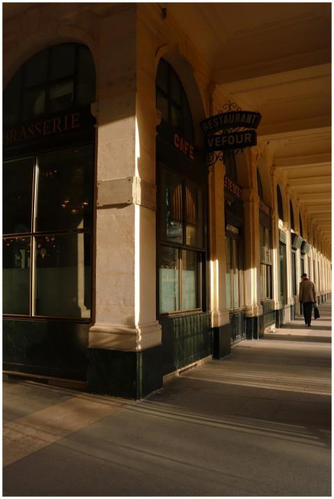 Sunlit corridor of Paris' Palais Royal highlightin